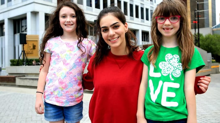 Noor Tajik et ses deux filles posent et sourient.