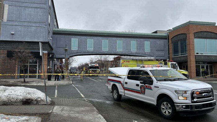 Une scène délimitée par du ruban jaune et un camion du service de sécurité incendie.