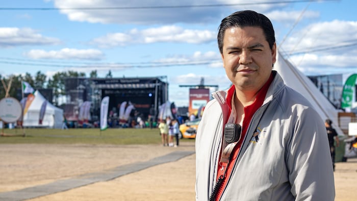 Normand Junior Thirnish-Pilot devant une scène de musique à l'extérieur.