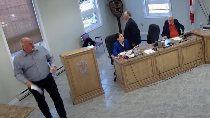 Une capture d'écran de la réunion du conseil municipal de Baie-des-Hérons. On voit deux hommes quitter la pièce.