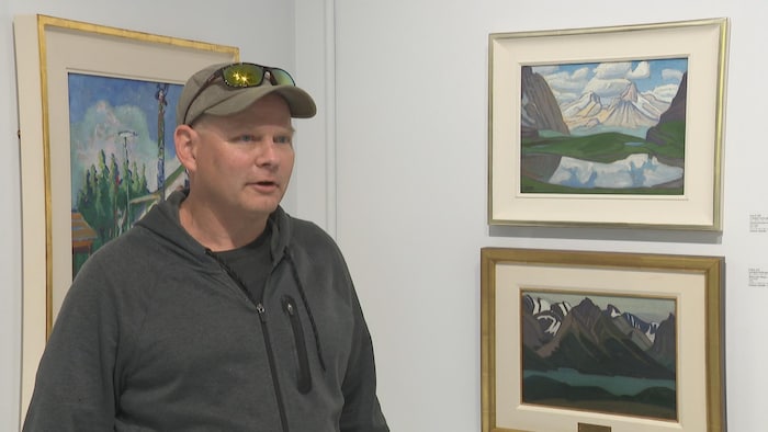 Norm Ederle devant les huiles sur panneau de Lawren Harris.