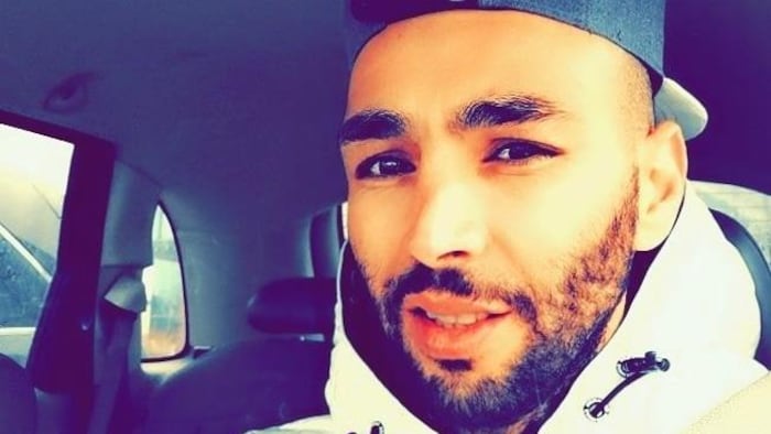 Un homme à la place du conducteur dans une voiture.