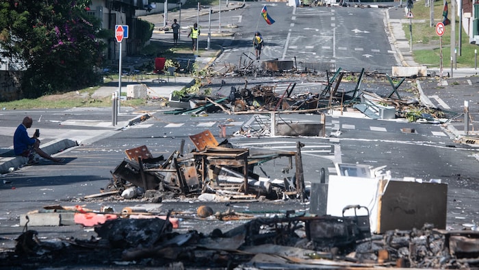 Une rue bloquée par des débris et des objets brûlés après une nuit de troubles dans le quartier de Magenta à Nouméa, en Nouvelle-Calédonie le 18 mai 2024. 