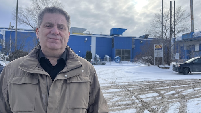 Un homme prend la pose devant l'usine Novelis à Arvida.