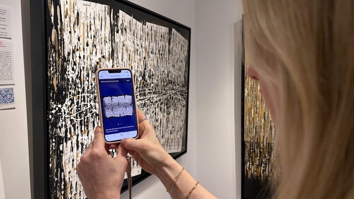 La journaliste scanne un code QR. 
