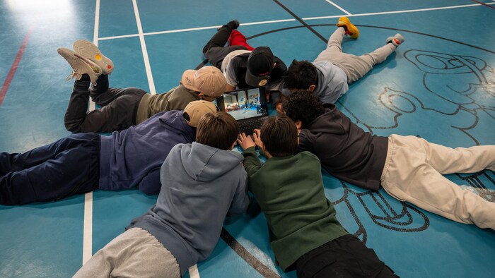 Les jeunes regardent un ordinateur.