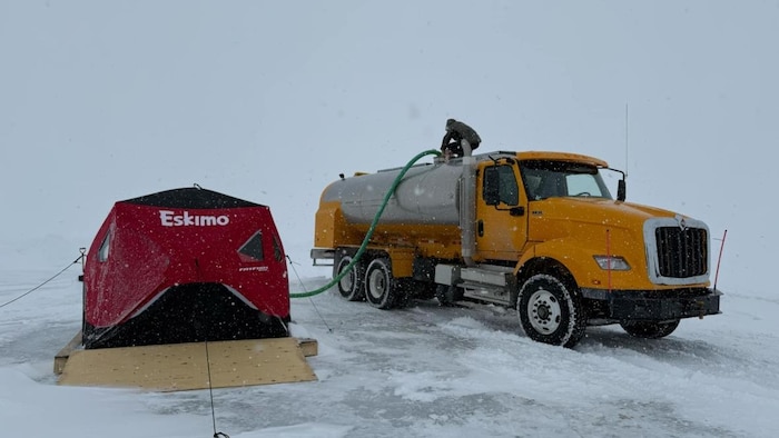 Un camion-citerne pompe de l'eau à même la station de pompage, près de Puvirnituq, au Nunavik. 
