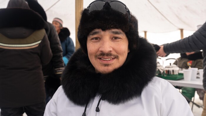 Bobby Tarkirk sourit à la caméra dans une tente.