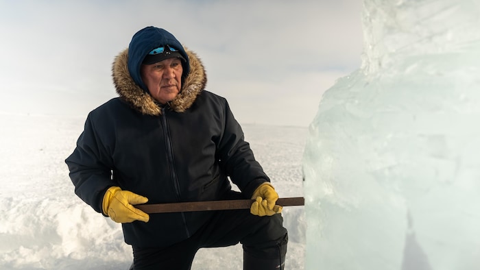 Muncy Novalinga taille un morceau de glace.