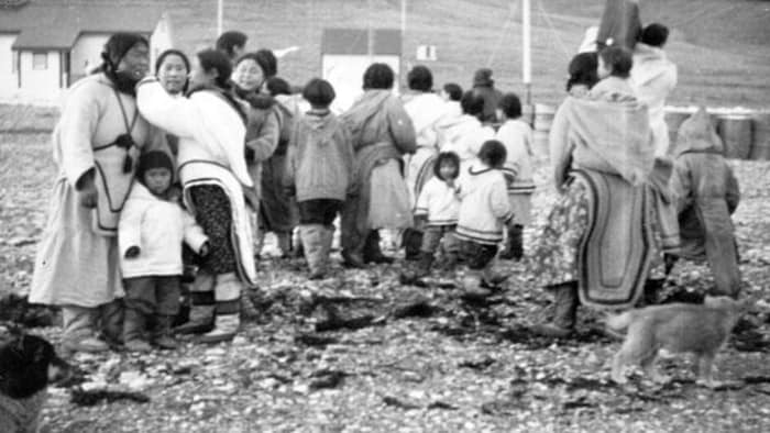 Photo d'archives prise en 1944 montrant des femmes et des enfants avec des bâtiments en arrière-plan. 
