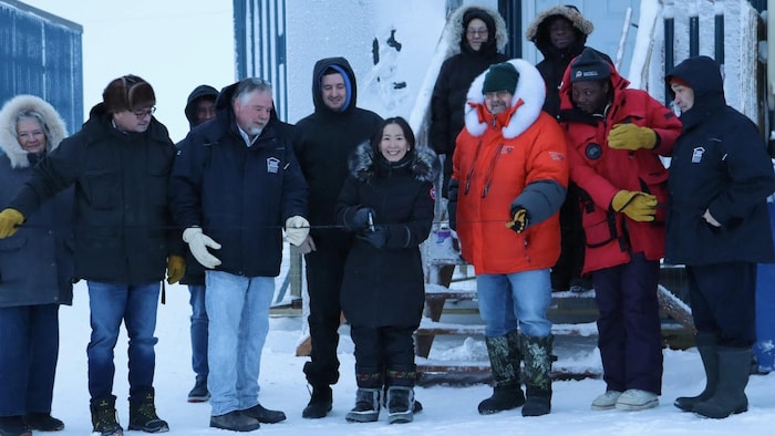 Cecile Nelvana Lyall,  ministre responsable de la Société d'habitation du Nunavut, coupe un ruban.