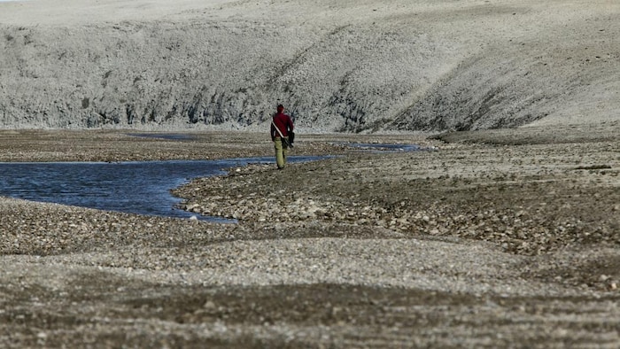 Une personne de dos marche à proximité du cratère de Haughton, sur l'île Devon, au Nunavut. 
