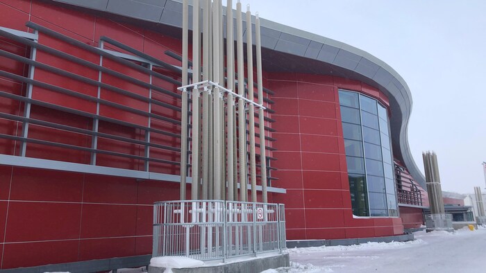 Façade d'un édifice avec de longs tuyaux qui montent vers le haut.