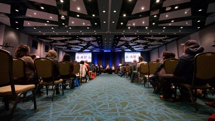 Des personnes sont assises sur des chaises et écoutent une conférence à Iqaluit, le 4 décembre 2023.