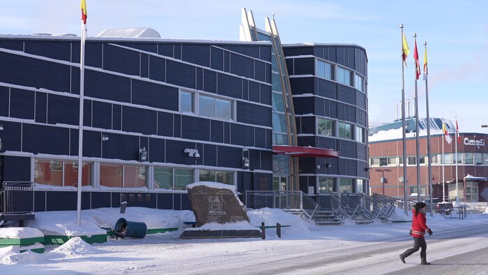 Una mujer cruza la calle frente a la Asamblea Legislativa de Nunavut, en Iqaluit, el 22 de febrero de 2023.