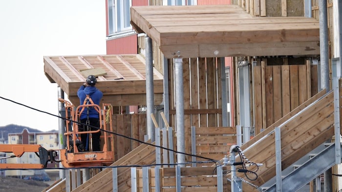 Un travailleur en construction travaille sur un chantier d'Iqaluit dans un camion-grue.