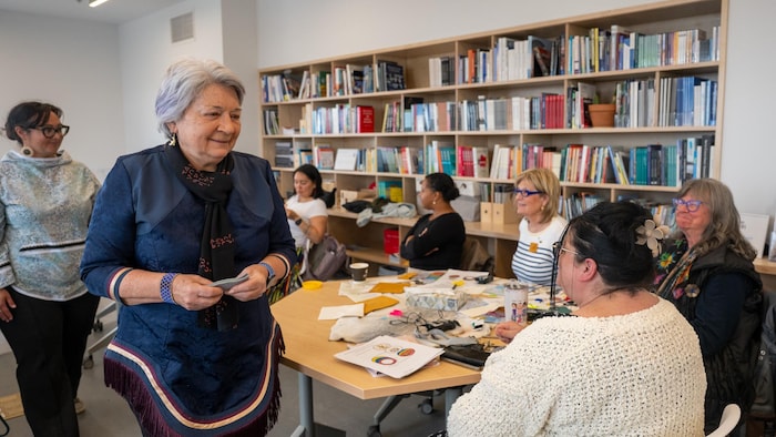 Mary Simon marche dans l'une des salles du centre de bien-être communautaire Inuusirvik d'Iqaluit où sont assises plusieurs femmes, au Nunavut, le 8 juillet 2025.
