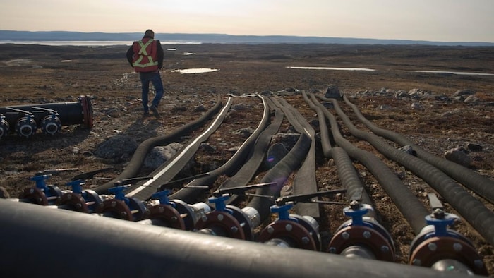 Des tuyaux sont posés au sol pour puiser l'eau depuis la rivière Apex, près d'Iqaluit.
