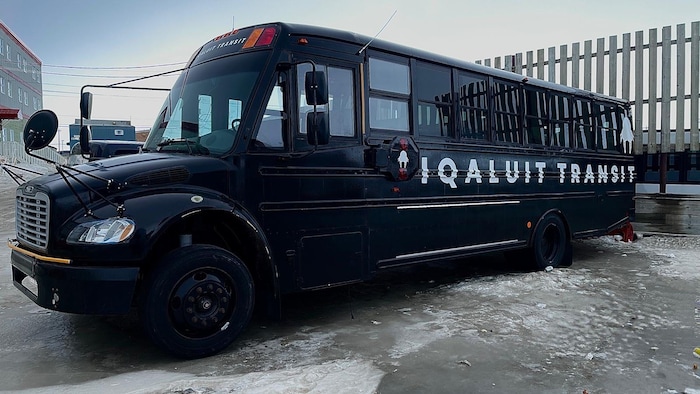 Un autobus peint en noir est stationné sur une rue glacée à Iqaluit, au Nunavut, en avril.2024.