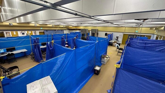 Des bâches font office de séparation entre différents postes de dépistage de la tuberculose, dans la salle communautaire de Pangnirtung, au Nunavut, à l'automne 2023.