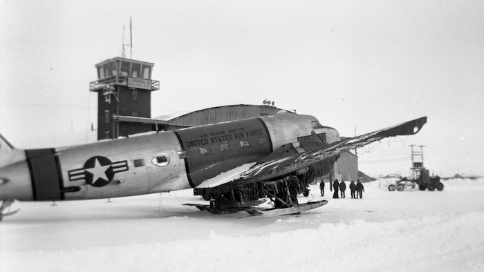 Une photographie d'archives en noir et blanc montrant un avion de l'armée de l'air américaine à la base militaire de Frobisher Bay.