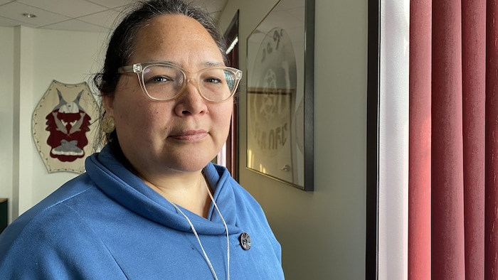 Une femme se tient devant une fenêtre dans son bureau, à Iqaluit, au Nunavut, le 29 juin 2023.