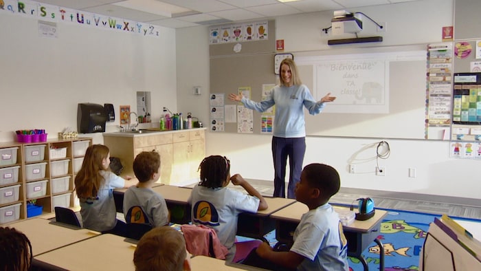 Marie-Josée parlent devant une classe.