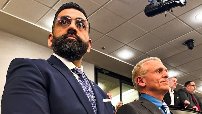 Obby Khan se tient à la droite de Wally Daudrich en attendant impatiemment les résultats de la course à la chefferie.