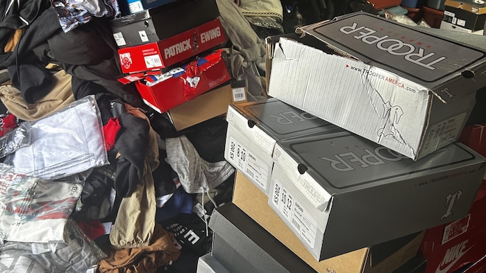 Des piles de boîtes de chaussures et de vêtements dans un local.