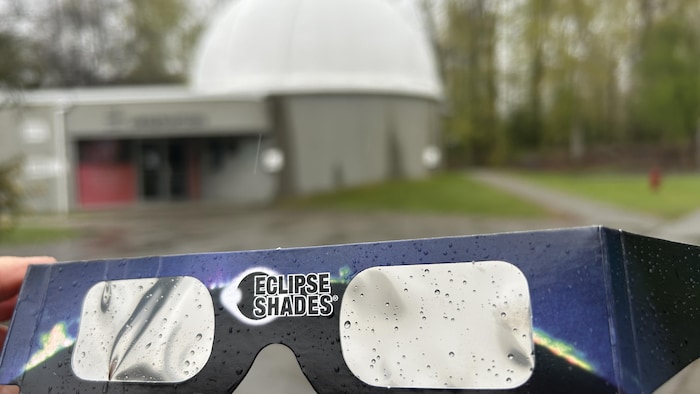 Des lunettes de protection contre l'éclipse sous la pluie, devant l'observatoire.