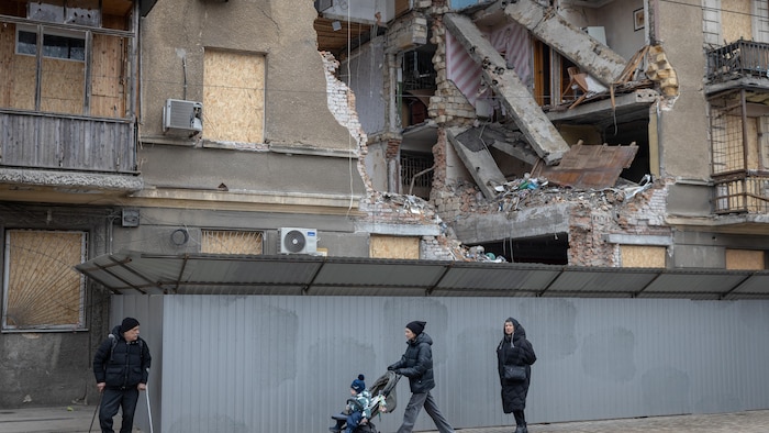 Des piétons passent devant un immeuble résidentiel fortement endommagé à la suite d'une attaque aérienne, à Odessa.
