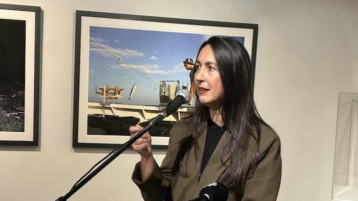 Isabelle Thériault s'exprimant à un micro dans une galerie d'art.