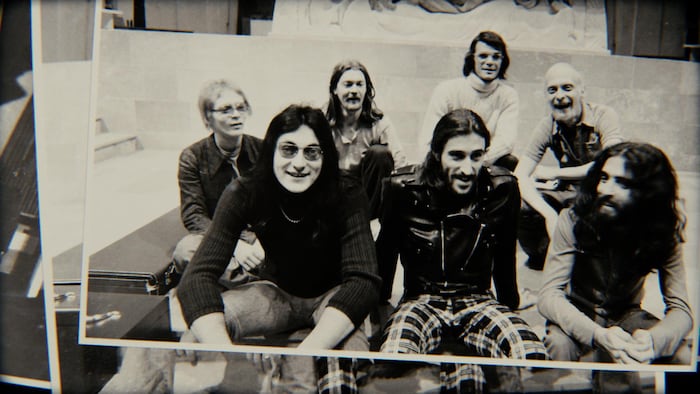 Les sept membres du groupe posent et sourient. 