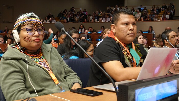 Une femme et un homme autochtones assistent à une assemblée.