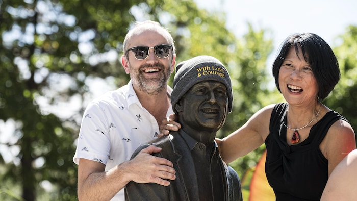 Olivia Chow et Mike Layton posent devant la statue de Jack Layton le jour de l'anniversaire de son décès, à Toronto.