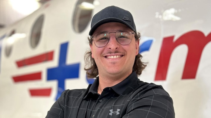 Olivier Blouin smiles, his arms crossed, in front of a helicopter. helicopter crushing: names victims revealed