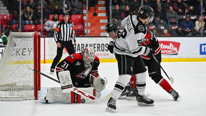 Le gardien des Huskies, Samuel Meloche, arrête une rondelle.