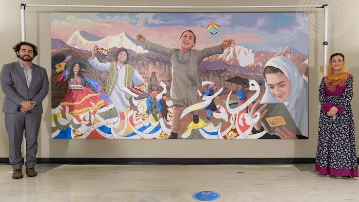 Des personnes devant une murale.