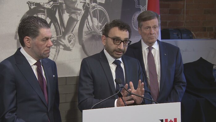 Le secrétaire parlementaire du premier ministre, Omar Alghabra, entouré du PDG de la chaîne de restaurants Paramount, Mohamad Fakih (à gauche) et du maire de Toronto, John Tory (à droite). 