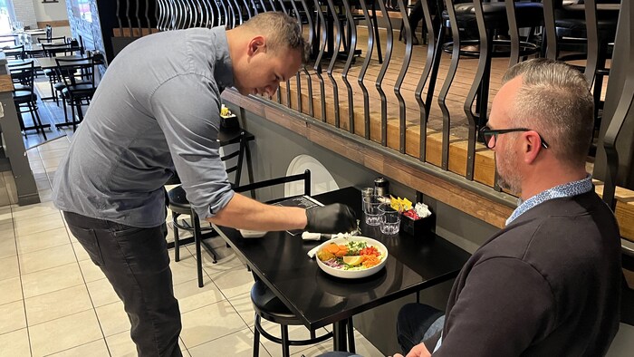 Omar Ben Chedly termine la présentation d'un plat devant un client.
