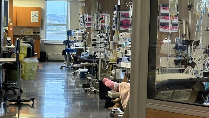 L'un des côtés d'une salle remplie d'équipements médicaux est séparé par plusieurs rideaux.