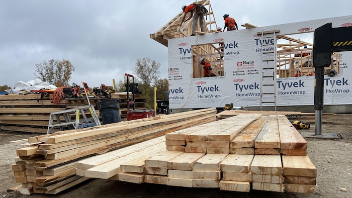 Des ouvriers en train de construire la charpente d'une maison.