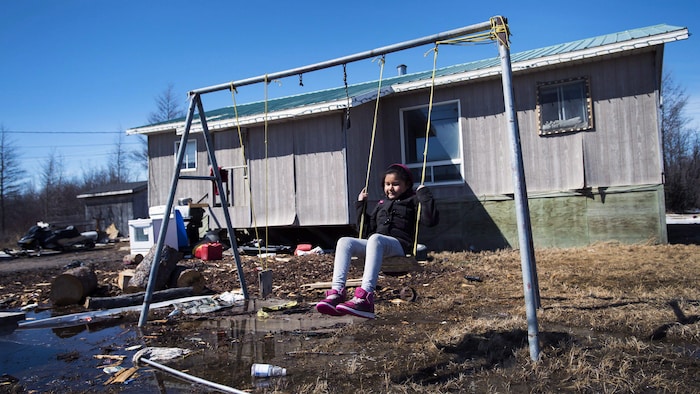 Une jeune fille se balance dans une réserve autochtone à Attawapiskat, en Ontario.
