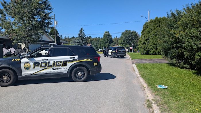 Des véhicules de police bloquent une rue.