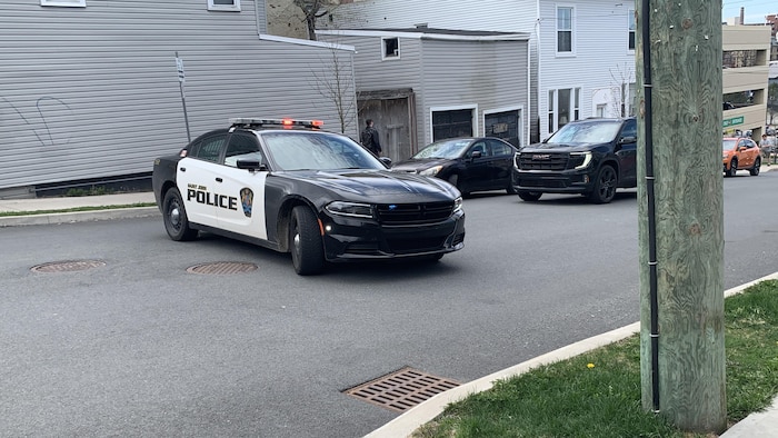 Une voiture de police bloque le passage à un véhicule.