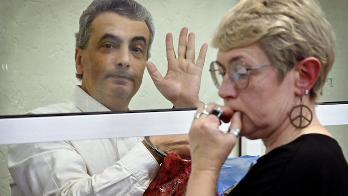Le politicien du parti d'opposition Iabloko, Lev Shlosberg, à côté de sa femme Zhanna Shlosber-Kozlovich, salue la caméra alors qu'il est menotté.
