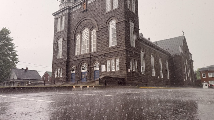La pluie ruisselle dans le stationnement de l'église de Saint-Tite. 