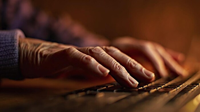 Un internaute tape sur un clavier d'ordinateur.