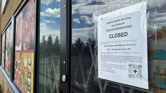Une ordonnance de fermeture de la santé publique albertaine est affichée sur la porte d'une épicerie.