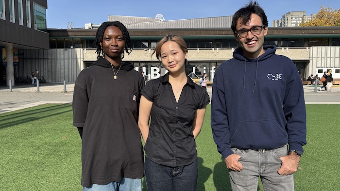 Trois jeunes sur un terrain de sport, sur un campus universitaire.